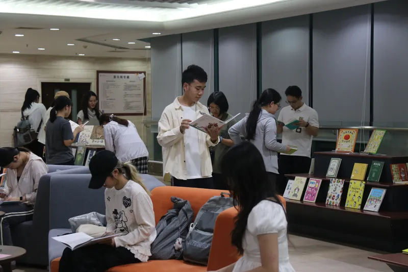 参与者在绘本展架旁自由翻阅书籍